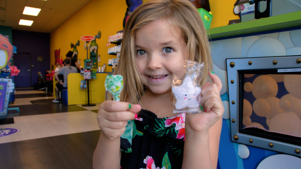 Kid holding prizes from "magic box"